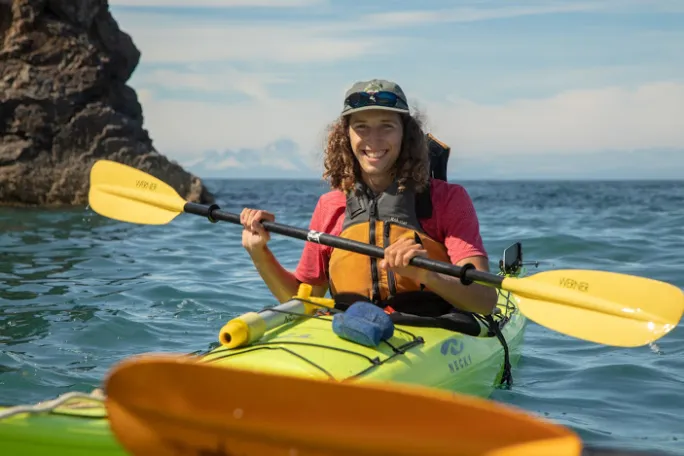 a person in a yellow boat sitting on top of a body of water