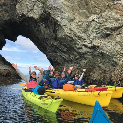kayakers throwing hands in air on trip
